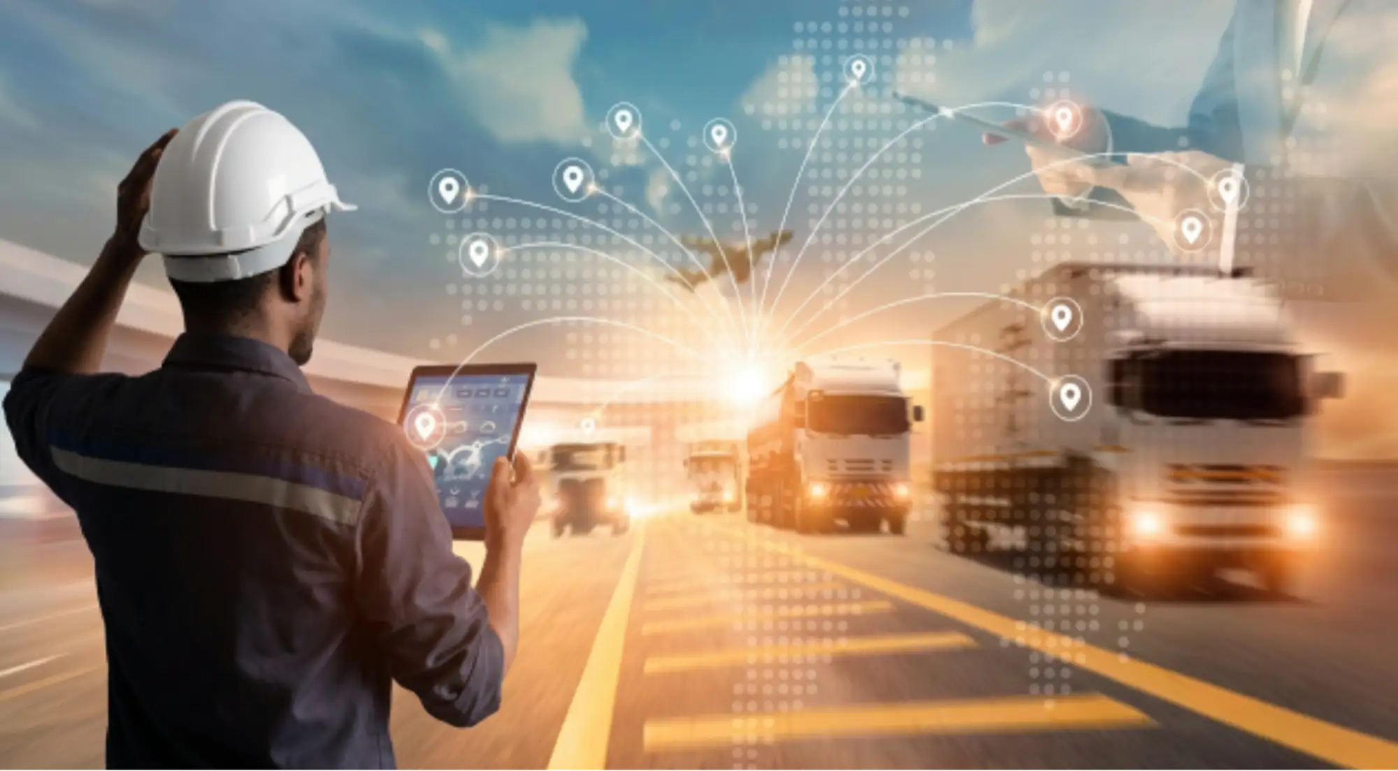 Logistics coordinator with a tablet tracking shipments as trucks move along the road